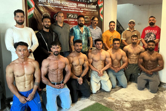 Bodybuilders posing along with dignitaries during a programme.