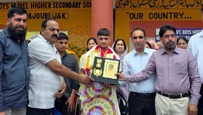 School management presenting a memento to boxer Yasser during a programme at GBMHSS Rajouri. -Excelsior/Imran