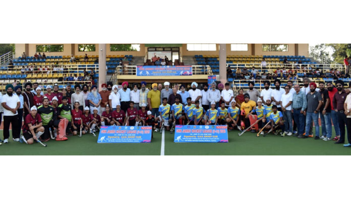 Hockey players posing along with dignitaries during a programme.