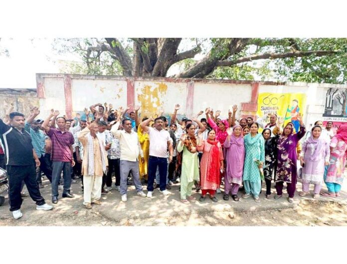 Safai Karamcharis protesting in front of the office of Municipal Committee Udhampur on Tuesday. Safai Karamcharis protesting in front of the office of Municipal Committee Udhampur on Tuesday.